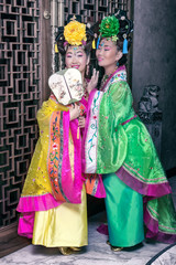 Fototapeta na wymiar two geishas whispering in traditional Chinese national dresses
