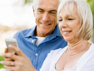 Happy senior couple looking at smartphone