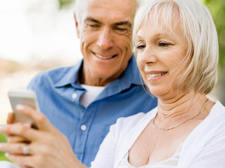 Happy senior couple looking at smartphone