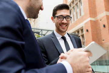 Two businessmen talking outdoors