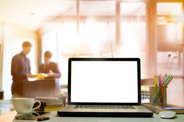 side view of laptop with blank screen on table in modern office.