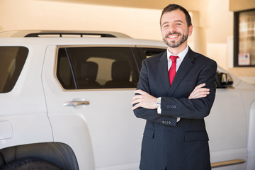 Happy salesman at a car dealership