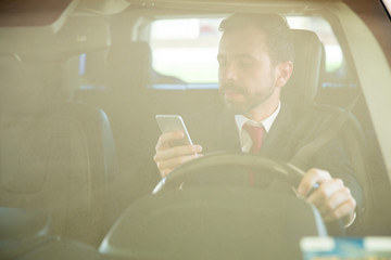 Man texting while driving a car
