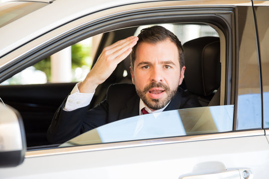 Businessman suffering from road rage and cursing while driving