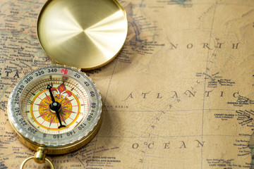 the old gold compass with cover on vintage map, macro background © YOR