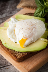 Healthy sandwich with avocado and poached eggs. Healthy food and diet concept.