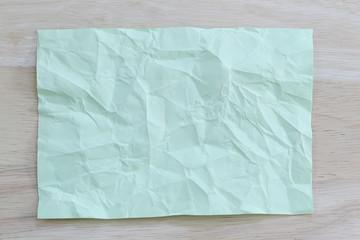 Obraz premium Green notepad paper wrinkled of empty and copy space on wooden b