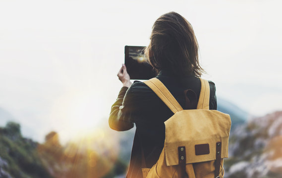 Hipster girl with backpack enjoying sunset on peak mountain, tourist traveler taking pictures landscape on mobile sell phone camera on background valley view mockup, hiker photographing in trip