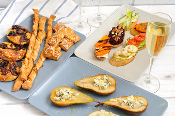 Sparkling wine and snacks on a wooden white table