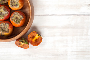 Ripe Persimmon fruit in a wooden bowl