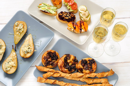Sparkling wine and snacks on a wooden white table