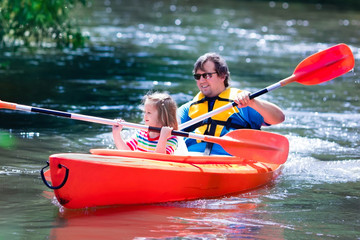 Father and child kayaking in summer