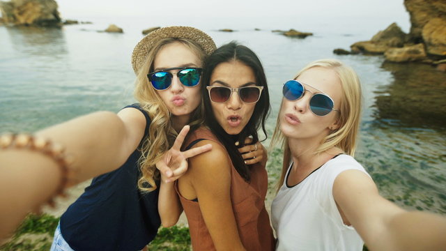 Three beautiful ladies taking selfies.
