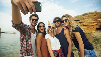 Five friends taking selfies .