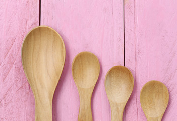 Wooden spoon on pink wood floors.