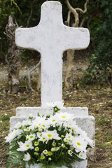 Burial with cross and flowers in the cemetery