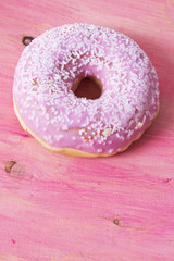 Donut on pink wooden background