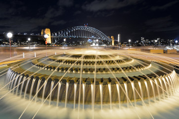 Fototapeta na wymiar Water fountain against Sydney Harbour Bridge at night