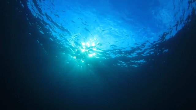 Underwater blue background in sea with sun in ocean