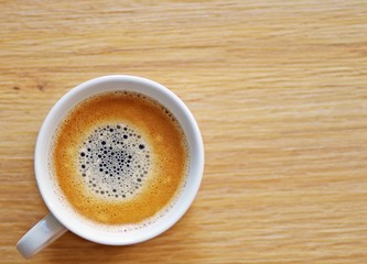 Cup of coffee on a wooden background ready for breakfast in the morning.