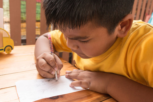 Cute Child Asian Little Boy Doing Homework On Table