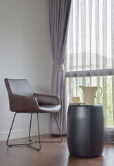 Dark brown chair at the corner with ceramic coffee set on the table