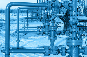 Group of wellheads. Oilfield during winter time. Oil and gas concept. Toned.