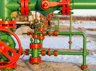 Group of wellheads. Oilfield during winter time. Oil and gas concept.