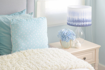 Light blue pillows and cream puffy blanket in light blue interior bedroom