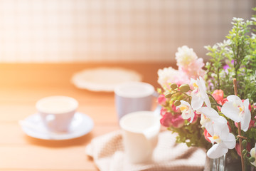 Blue and white coffee cups on wood table with flower bouquet dec