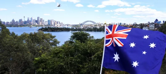 Poster Im Rahmen Die Nationalflagge von Australien weht entlang der Skyline von Sydney © Rafael Ben-Ari