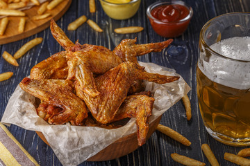 Buffalo wings with french fries and beer.