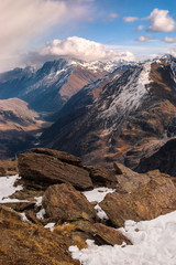Ski resort Cheget. View on the Main Caucasian ridge and Baksan gorge. Textured stones with lichen covered with snow in the foreground. Caucasus