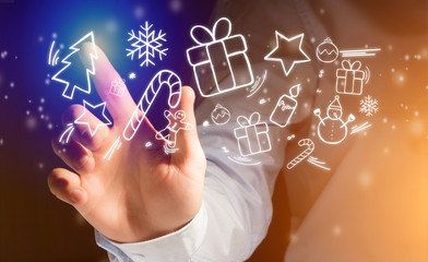 Hand of a man touching interface with christmas icon around