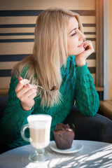 Close-up portrait of the beautiful woman with a coffee and chocolate muffin.