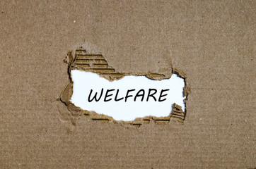 The word welfare appearing behind torn paper