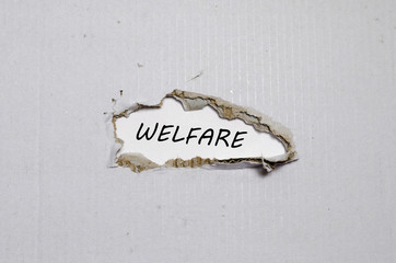 The word welfare appearing behind torn paper