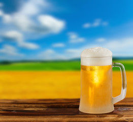 cold glass mug of beer in a landscape