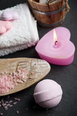 Obraz na płótnie Canvas bath bomb closeup with pink lit candle