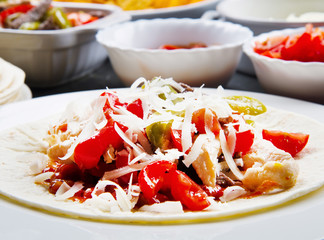Beef and chicken fajitas with colorful bell peppers in  tortill