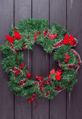 Christmas wreath on a rustic wooden front door.