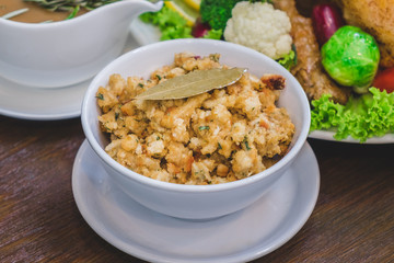 Close up of Thanksgiving turkey stuffing made with bread and herb on a wooden table.