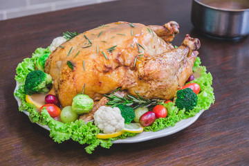 Roasted turkey stuffing garnished with Vegetables served with gravy sauce on a rustic style table. Christmas Dinner