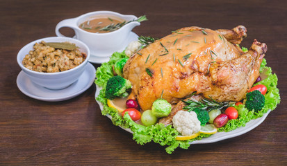 Roasted turkey stuffing garnished with Vegetables served with gravy sauce on a rustic style table. Christmas Dinner
