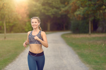 Junge Frau hört Musik mit dem Smartphone beim Jogging