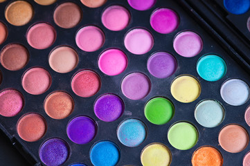 Make-up colorful eyeshadow palettes isolated on black background