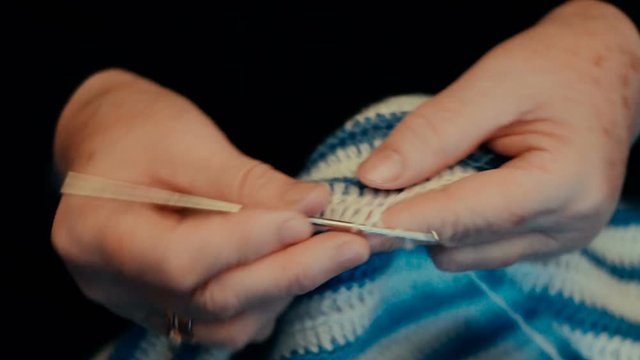 Grandma hands doing knitting. Close-up view.