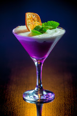 сливочный ежевичный мусс с долькой апельсина на темном фоне