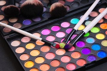 Make-up colorful eyeshadow palettes isolated on black background