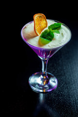 сливочный ежевичный мусс с долькой апельсина на темном фоне